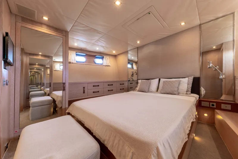  Yacht Photos Pics Luxurious bedroom interior of 2006 Mangusta 80 yacht with elegant decor and ambient lighting.