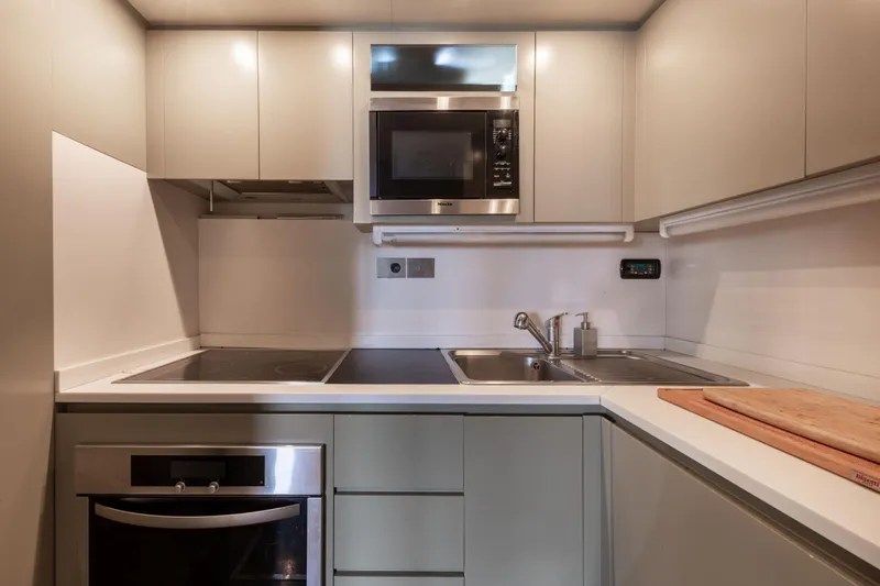  Yacht Photos Pics Modern kitchen in a 2006 Mangusta 80 yacht, featuring sleek cabinetry and appliances.