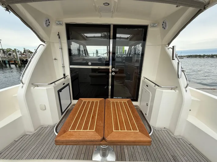  Yacht Photos Pics 2007 Riviera 3600 Sport Yacht cockpit with wooden table, overlooking marina.