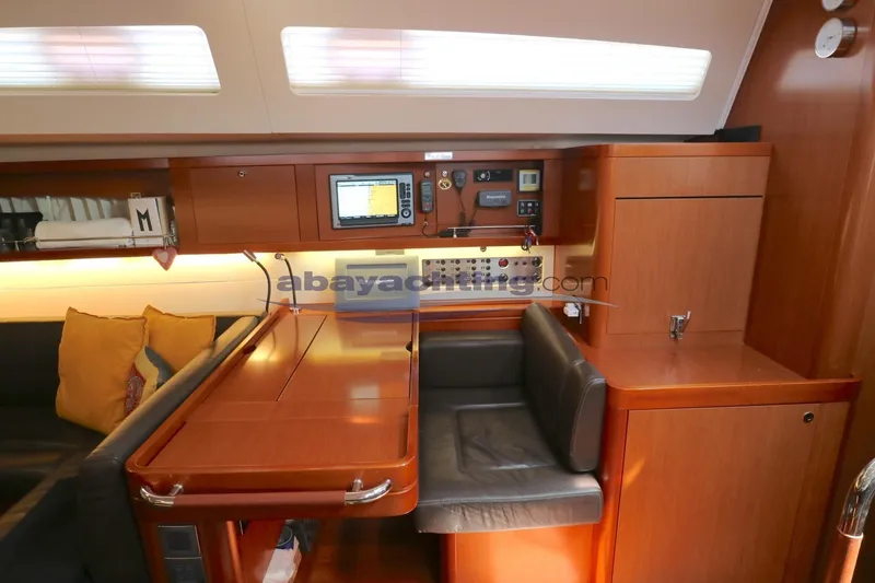  Yacht Photos Pics Interior of 2010 Beneteau Oceanis 58 yacht with navigation station and seating area.