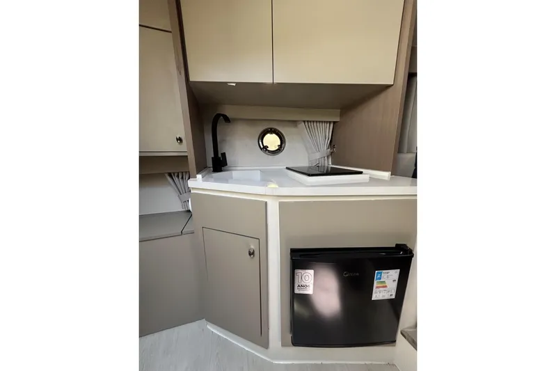  Yacht Photos Pics Modern L'ACQUA LR350 2025 boat kitchenette with sink, compact fridge, and storage cabinets.