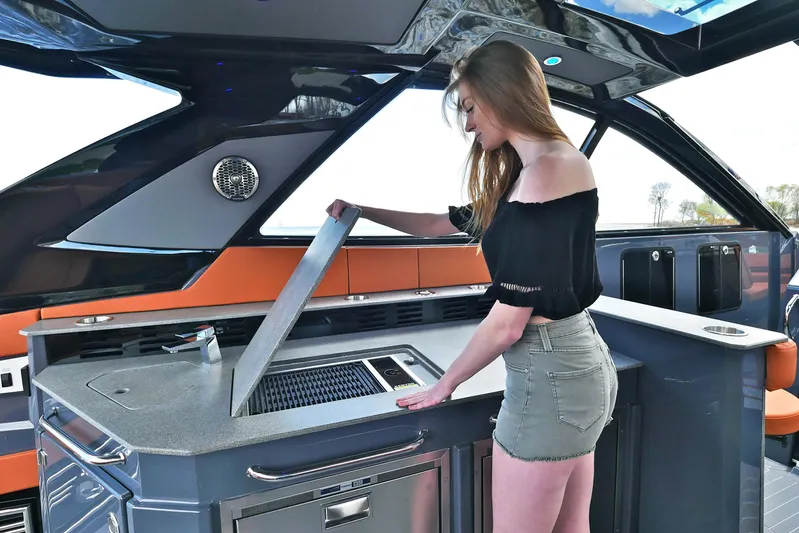  Yacht Photos Pics Woman using grill on 2026 Cruisers Yachts 42 GLS I/O luxury boat.