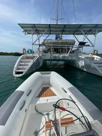  Yacht Photos Pics 2005 Lagoon 570 Switch catamaran docked, viewed from a small inflatable boat.