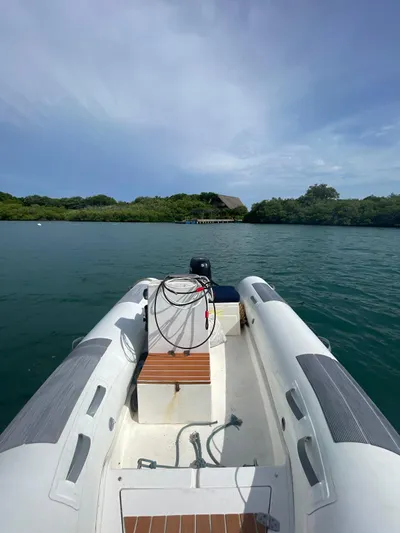  Yacht Photos Pics 2005 Lagoon 570 Switch boat on calm water, lush greenery in background.