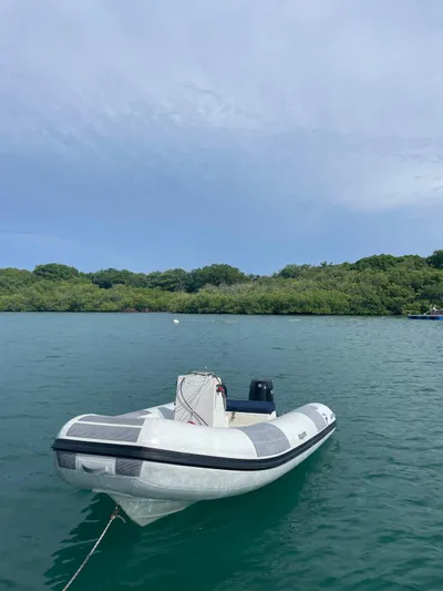  Yacht Photos Pics 2005 Lagoon 570 Switch boat on calm water with lush green shoreline.
