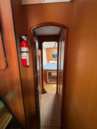  Yacht Photos Pics Interior hallway of 2005 Lagoon 570 Switch yacht with wood paneling and fire extinguisher.