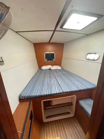  Yacht Photos Pics Cozy cabin interior of 2005 Lagoon 570 Switch yacht with striped bedding.