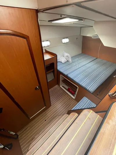 Yacht Photos Pics Interior cabin of 2005 Lagoon 570 Switch yacht with cozy bed and wooden finishes.