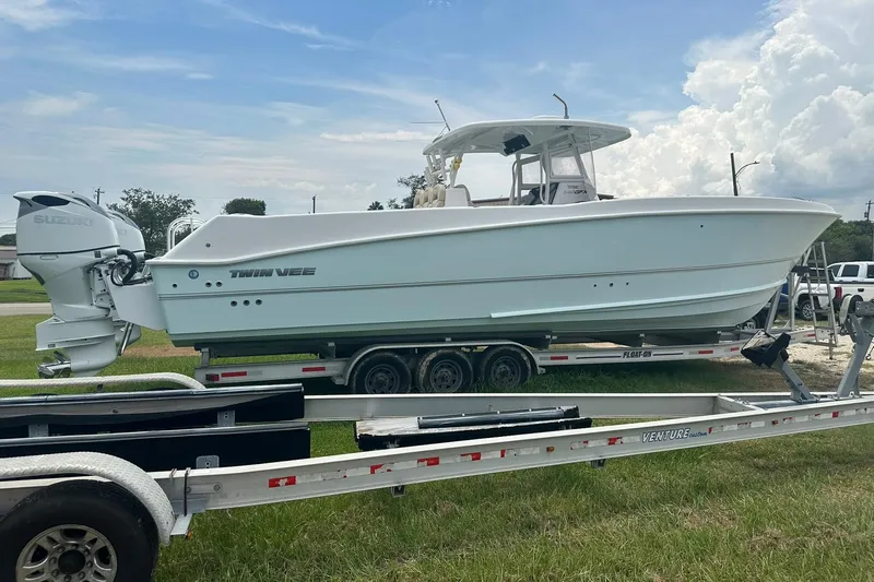 Cat Gone Willd Yacht Photos Pics 2023 Twin Vee 340 GFX CC boat on trailer, featuring Suzuki outboard motor.