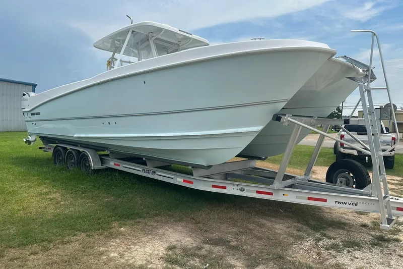 Cat Gone Willd Yacht Photos Pics 2023 Twin Vee 340 GFX CC boat on trailer, parked on grass.