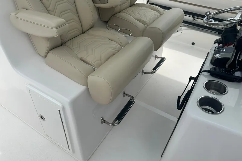 Cat Gone Willd Yacht Photos Pics 2023 Twin Vee 340 GFX CC boat interior with beige leather seats and steering console.