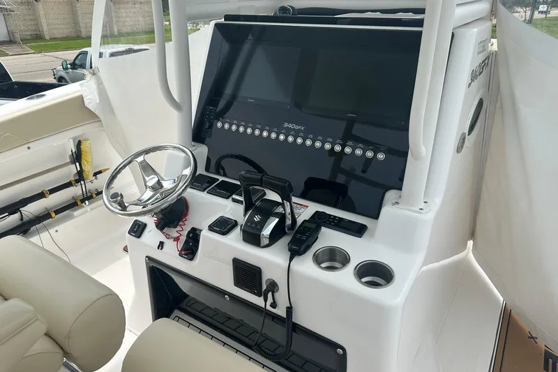 Cat Gone Willd Yacht Photos Pics 2023 Twin Vee 340 GFX CC boat console with steering wheel and controls.