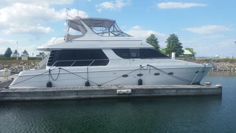Trades Welcome Yacht Photos Pics 1999 Carver 530 Voyager Pilothouse yacht docked at a marina.