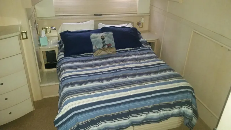 Trades Welcome Yacht Photos Pics 1999 Carver 530 Voyager Pilothouse bedroom with striped bedding and nautical-themed pillow.