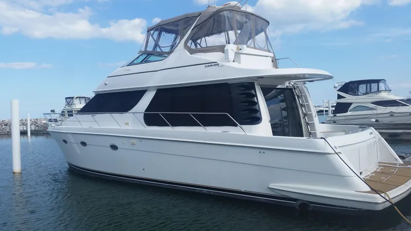 Trades Welcome Yacht Photos Pics 1999 Carver 530 Voyager Pilothouse yacht docked in a marina.