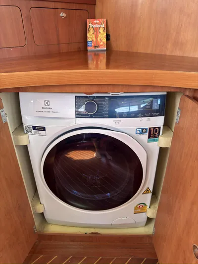 Adventure Yacht Photos Pics Washing machine in wooden cabinet on Antares 44i, 2013 model, with Thai food package on top.
