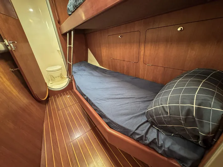 Adventure Yacht Photos Pics Cozy cabin interior of 2013 Antares 44i yacht with wooden finish and bunk beds.