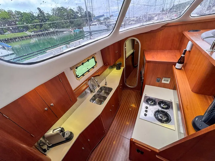 Adventure Yacht Photos Pics Interior of 2013 Antares 44i yacht, featuring a modern kitchen with wood cabinetry and appliances.