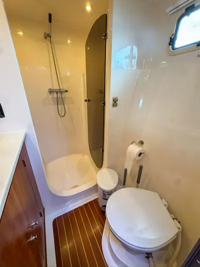 Adventure Yacht Photos Pics Compact bathroom in 2013 Antares 44i yacht with shower, toilet, and wooden flooring.