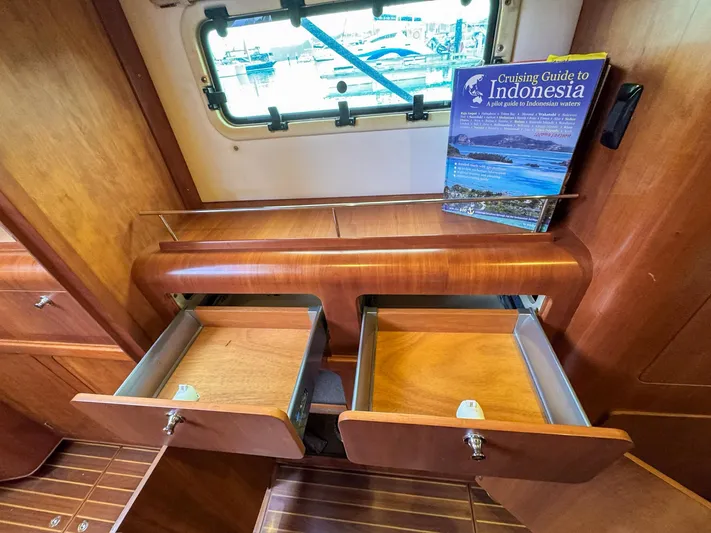 Adventure Yacht Photos Pics Wooden interior of 2013 Antares 44i yacht with open drawers and Indonesia cruising guide.