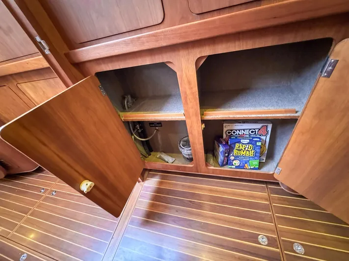 Adventure Yacht Photos Pics Open wooden cabinet on Antares 44i yacht, showing games and storage space, 2013 model.