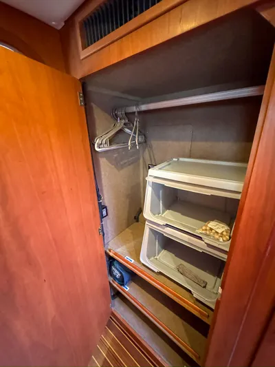 Adventure Yacht Photos Pics Wooden closet interior on 2013 Antares 44i yacht with hangers and storage bins.
