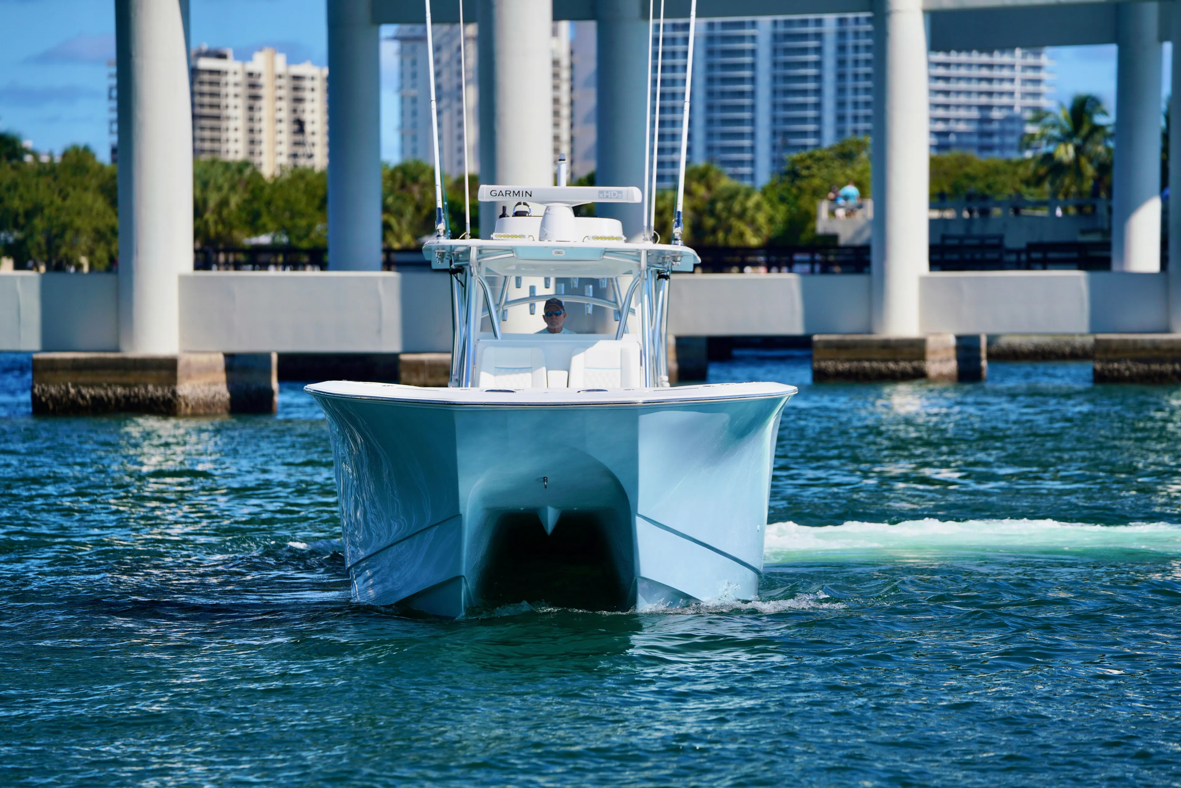 Yacht Photos Pics 2020 SeaHunter 46 CTS boat cruising under a bridge in a scenic urban setting.