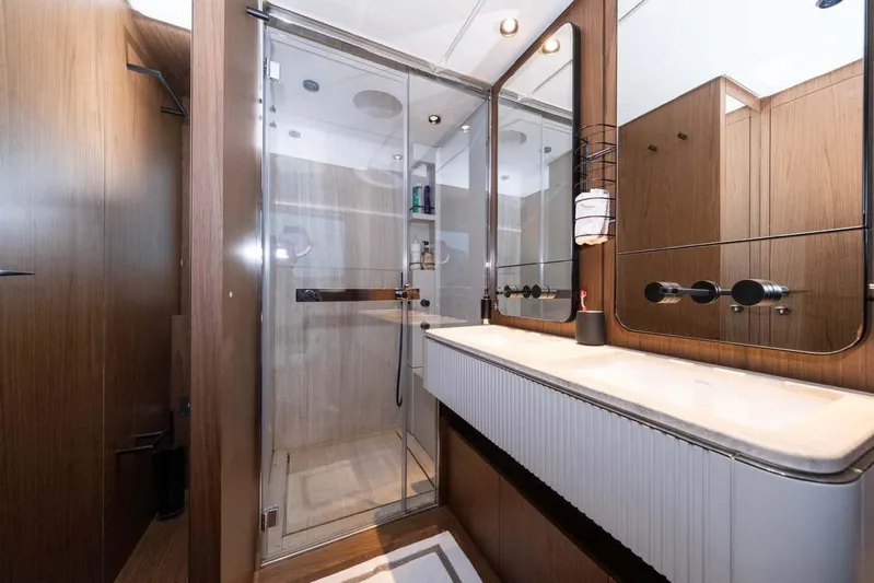  Yacht Photos Pics Luxurious bathroom in 2021 Ferretti Yachts 780, featuring modern wood finishes and glass shower.