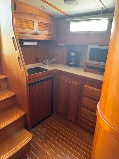  Yacht Photos Pics 2005 Sabre 38 yacht interior with wooden cabinetry and compact kitchen area.