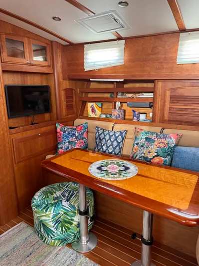  Yacht Photos Pics 2005 Sabre 38 yacht interior with cozy seating, vibrant cushions, and a polished wooden table.