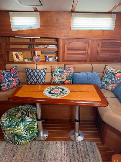  Yacht Photos Pics Interior of 2005 Sabre 38 yacht with colorful cushions and wooden table.