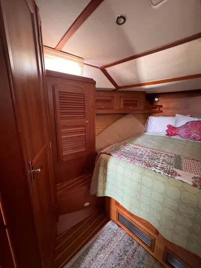  Yacht Photos Pics Cozy cabin interior of 2005 Sabre 38 sailboat with wooden furnishings and bed.