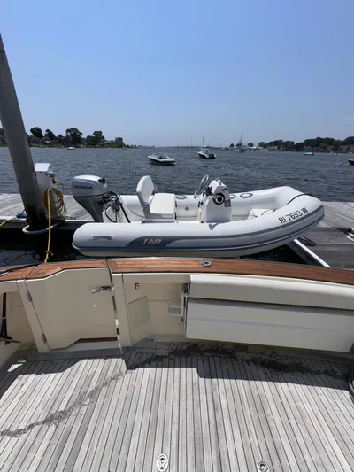  Yacht Photos Pics 2005 Sabre 38 yacht docked with inflatable boat on calm waters.