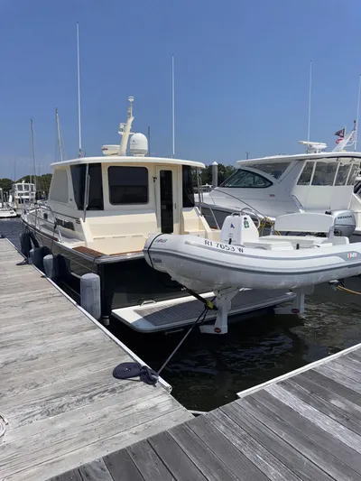  Yacht Photos Pics 2005 Sabre 38 yacht docked with inflatable boat, sunny day.