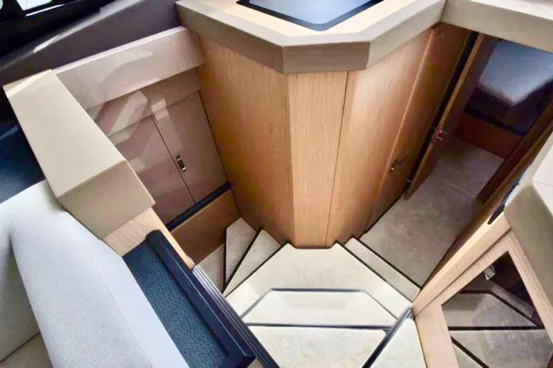  Yacht Photos Pics Luxurious interior of 2020 Beneteau Monte Carlo 52 yacht with elegant wooden staircase.
