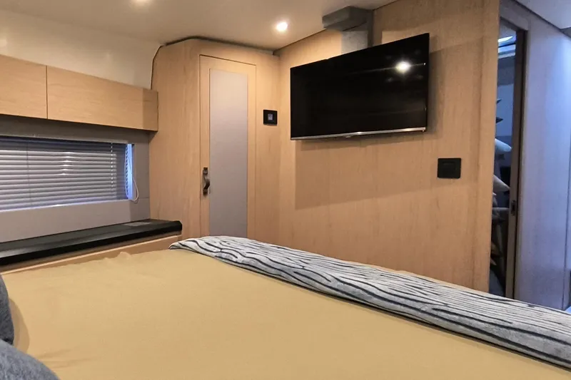  Yacht Photos Pics Interior of 2020 Beneteau Monte Carlo 52 yacht bedroom with TV and modern decor.