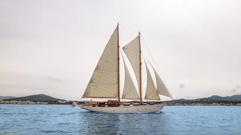 Armide Yacht Photos Pics 1938 Custom By Classic Works sailboat on calm waters with distant shoreline.