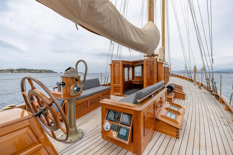 Armide Yacht Photos Pics 1938 Custom sailboat by Classic Works, wooden deck, steering wheel, and navigation instruments.