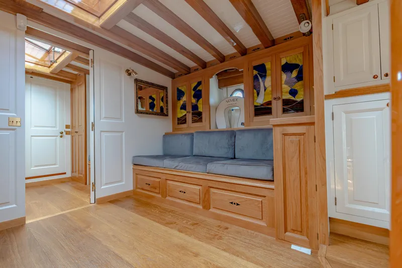 Armide Yacht Photos Pics 1938 Custom Classic Works interior with wooden cabinetry, stained glass, and built-in seating.