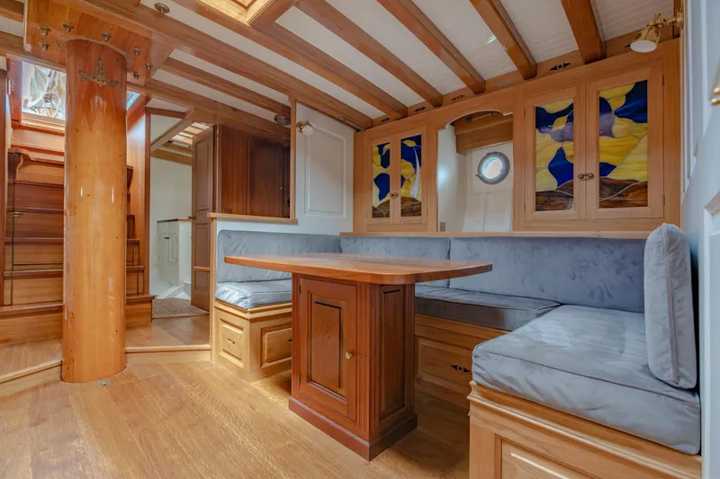 Armide Yacht Photos Pics 1938 Custom Classic Works yacht interior with wooden beams, stained glass cabinets, and cozy seating area.