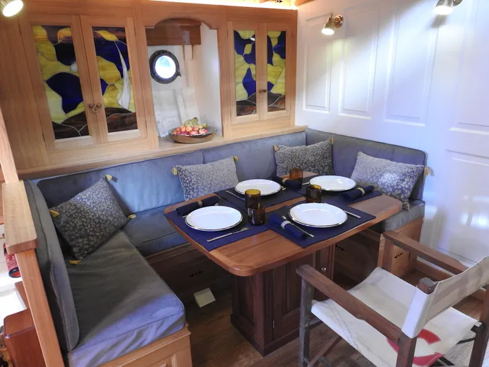 Armide Yacht Photos Pics 1938 Custom Classic Works interior dining area with stained glass cabinets and cozy seating.