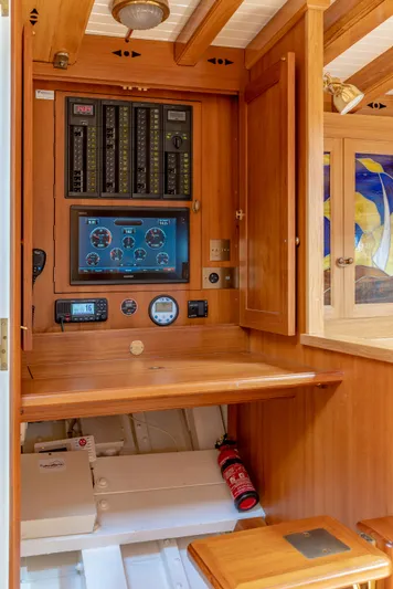 Armide Yacht Photos Pics 1938 Custom By Classic Works boat control panel with wooden cabinetry and fire extinguisher.