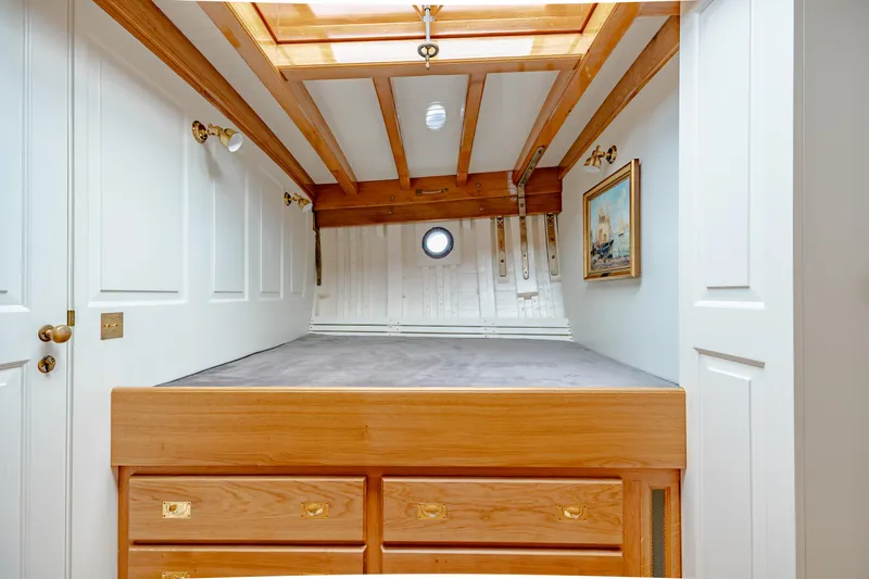 Armide Yacht Photos Pics 1938 Custom Classic Works boat cabin with wooden beams, skylight, and built-in storage drawers.