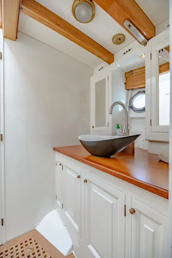Armide Yacht Photos Pics 1938 Custom Classic Works boat bathroom with wooden countertop and modern sink.