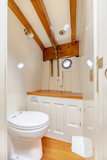 Armide Yacht Photos Pics 1938 Custom Classic Works boat bathroom with wooden beams and porthole window.