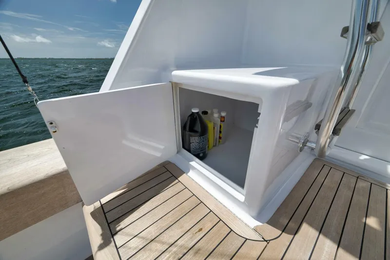 Bird Dog Yacht Photos Pics Open storage compartment on 1989 Jim Smith Custom Convertible boat deck with cleaning supplies.