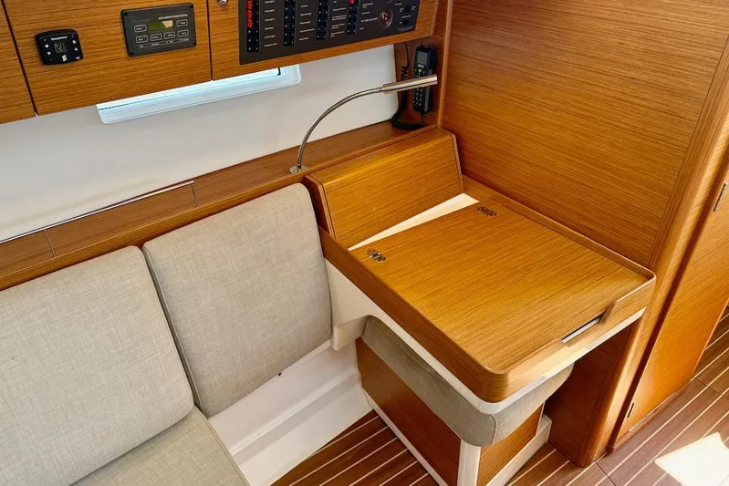 Spectre Yacht Photos Pics 2016 X-Yachts Xp38 interior with wooden navigation station and beige seating.