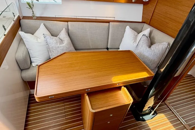 Spectre Yacht Photos Pics Luxurious interior of 2016 X-Yachts Xp38 with wooden table and cushioned seating.