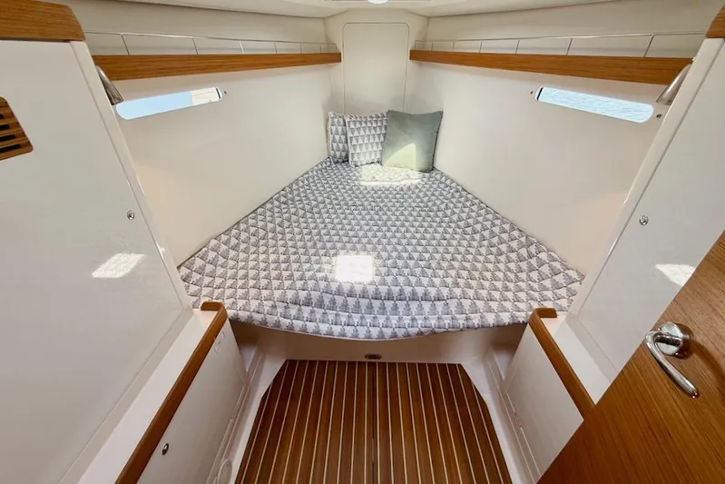 Spectre Yacht Photos Pics Cozy cabin interior of 2016 X-Yachts Xp38 with patterned bedding and wooden accents.