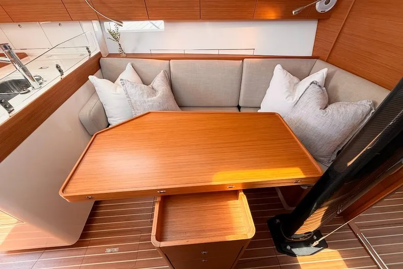 Spectre Yacht Photos Pics Luxurious interior of 2016 X-Yachts Xp38 with wooden table and cushioned seating.